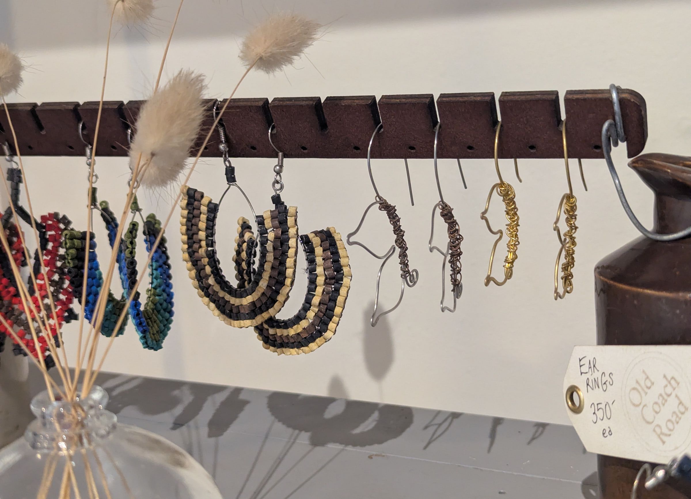 Wire earrings on a cut wooden bar